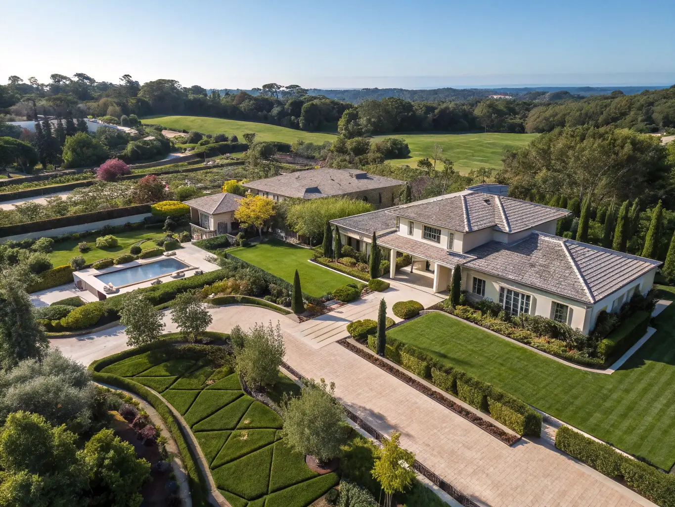 A high-definition aerial photograph of a luxury home with a sprawling lawn, showcasing the property's size and curb appeal. The image is bright and inviting, emphasizing the home's prime location and features.